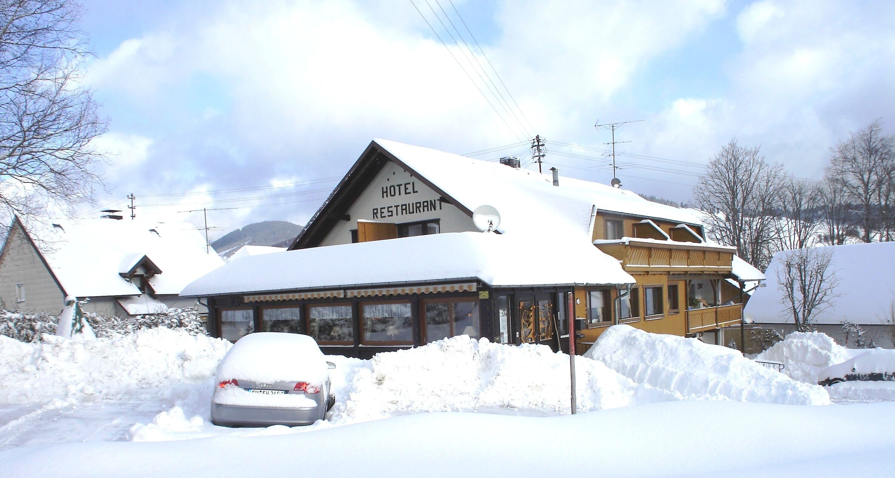 A hotel with a sign reading 'HOTEL RESTAURANT,' surrounded by snow.