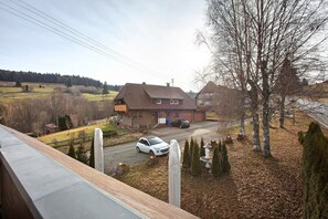 A residential house with a driveway, a parked car, and a clear view of the surrounding landscape. - Hotel Bären - Three Stars: Single Room 11 / Breakfast Included / 1 Person / WiFi (Bernau im Schwarzwald)