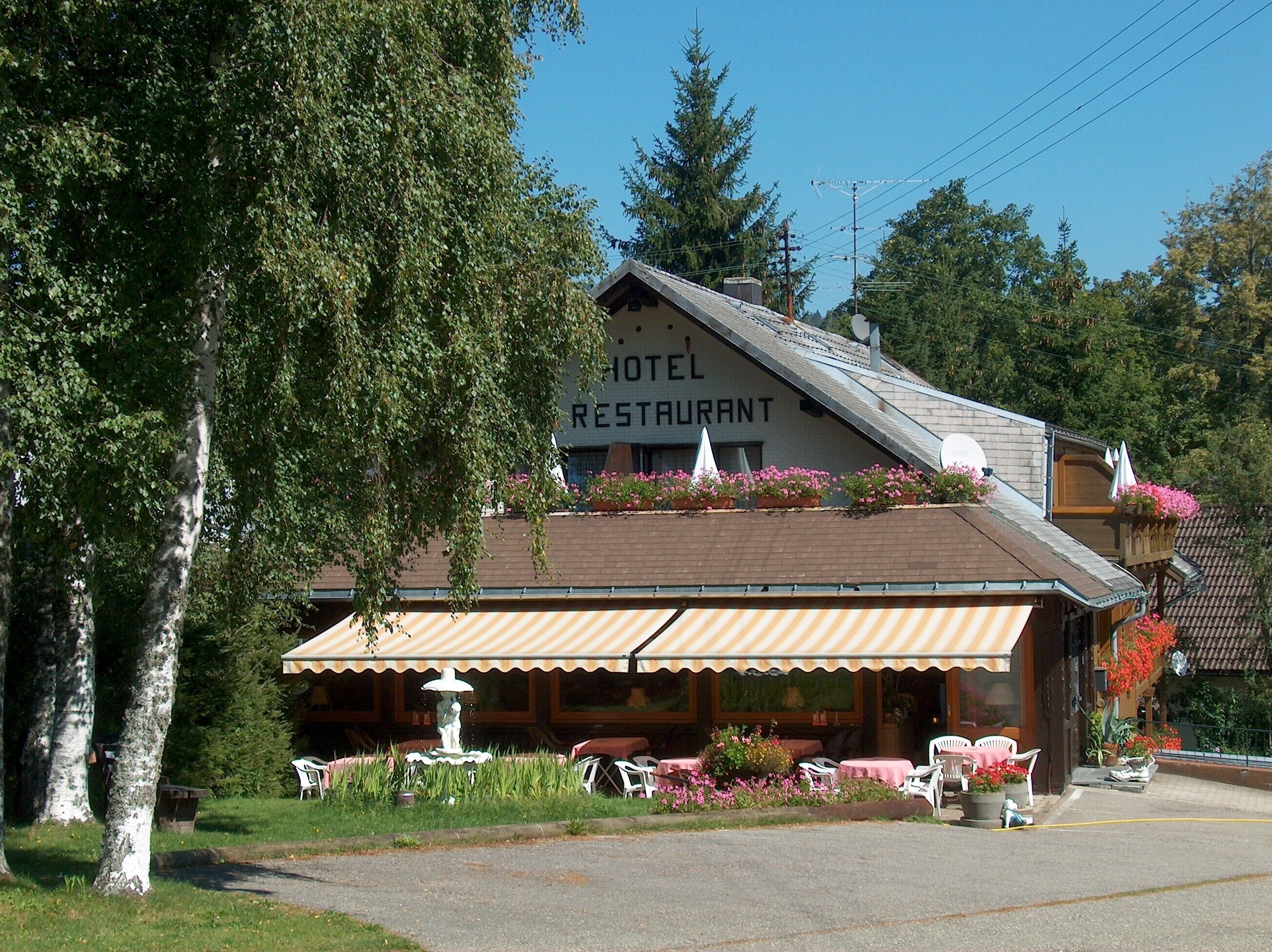 Un hôtel doté d’un restaurant, d’une terrasse et d’une fontaine.