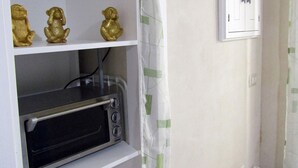 Eine Küche mit einem weißen Schrank, einem Toaster und drei goldenen Figuren.