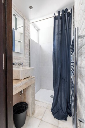 A bathroom with a marble sink, a mirror, a shower curtain, and a metal towel rack. - Modern Villa Biot, Entire home in Biot, France (Biot)
