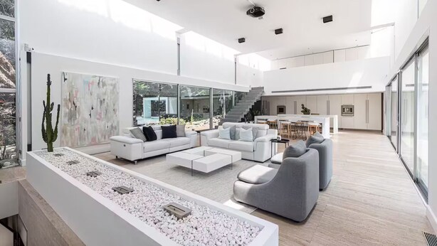 A spacious living area with a modern white sofa set, a coffee table, and a large window overlooking a garden. - Modern Villa Biot, Entire home in Biot, France (Biot)