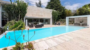 A modern house with a swimming pool, outdoor furniture, and various plants. - Modern Villa Biot, Entire home in Biot, France (Biot)