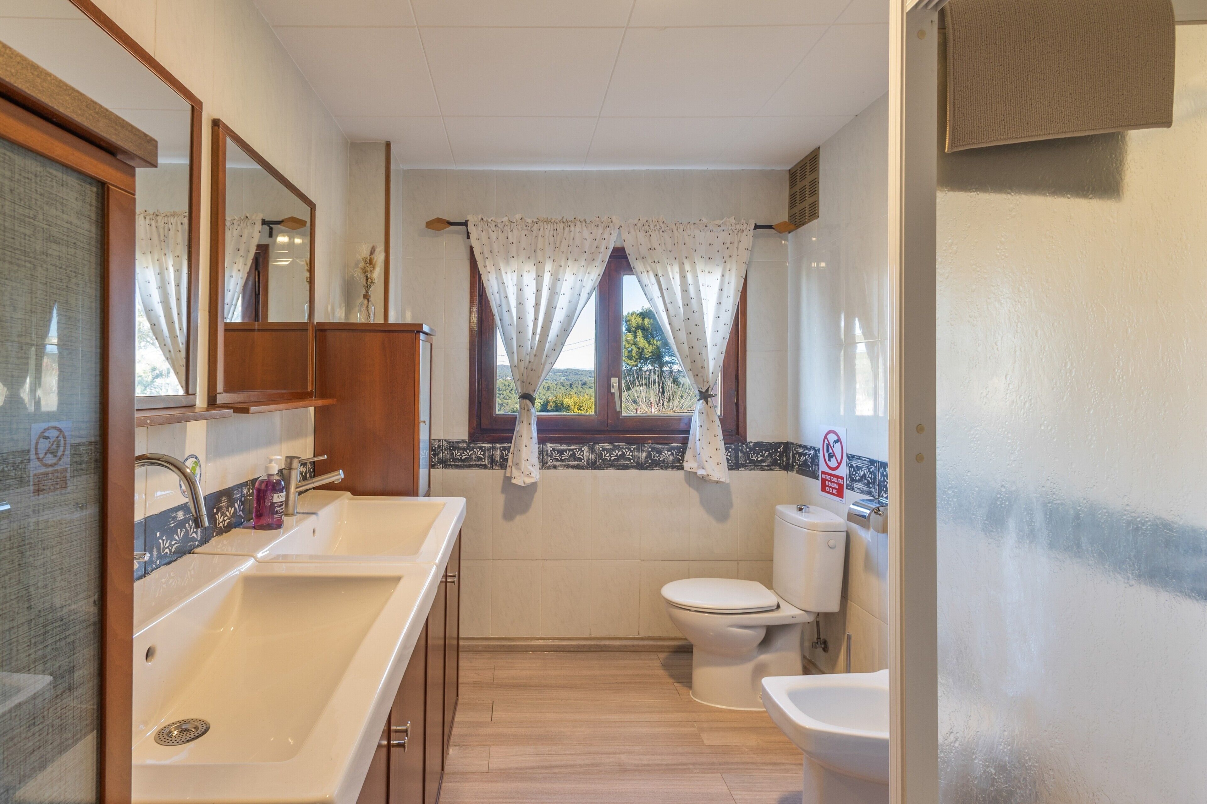 Un baño con lavamanos, inodoro y espejo.