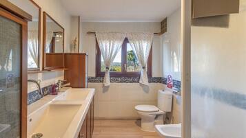 Un baño con lavamanos, inodoro y espejo.