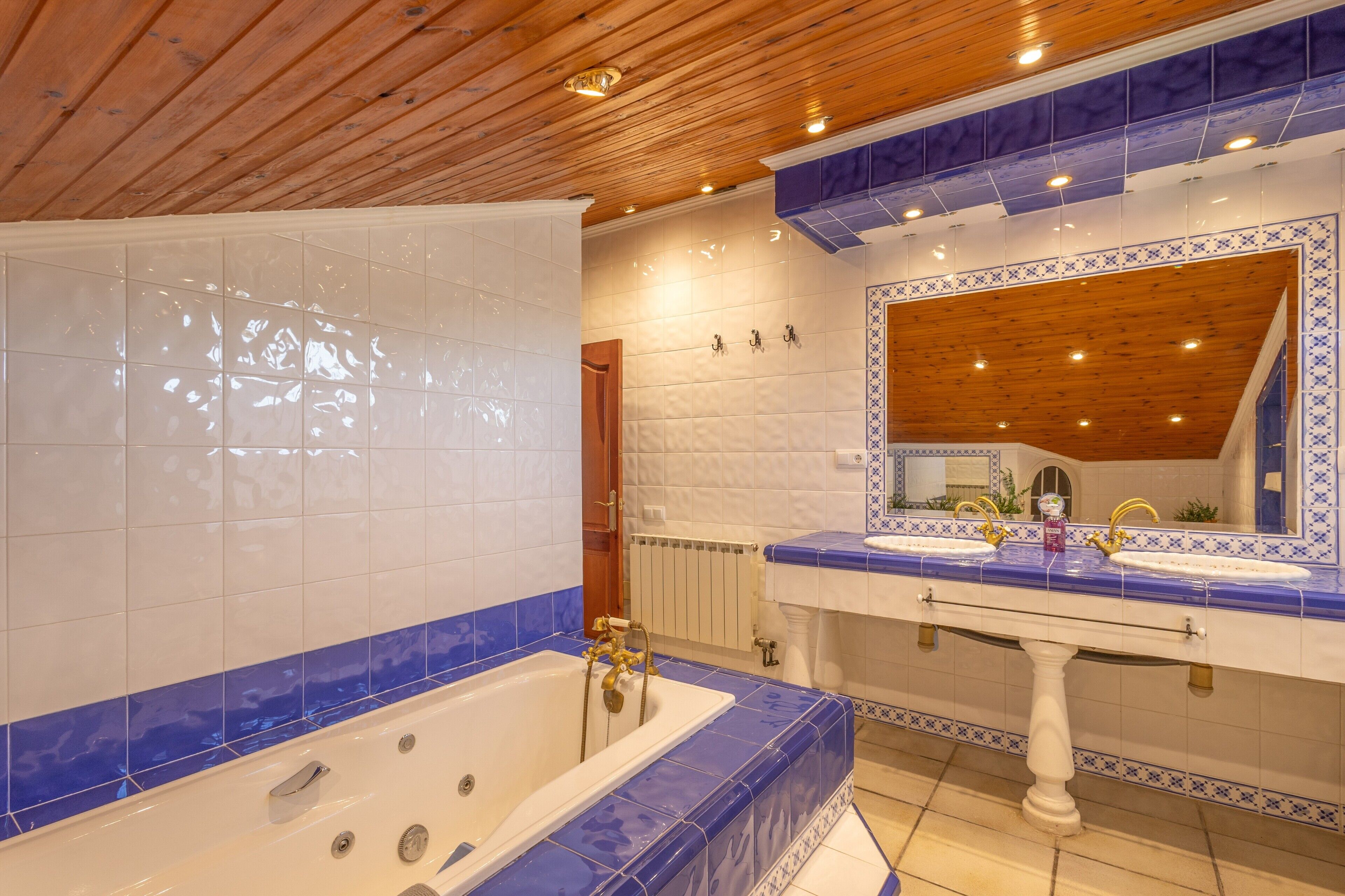 A bathroom with a bathtub, a sink, and a mirror.