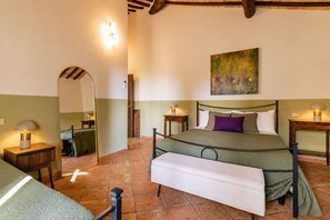 Una camera da letto con un letto, comodini, uno specchio e un quadro appeso al muro.