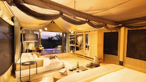 Un alloggio in tenda con letto, area salotto e vista sulla natura.