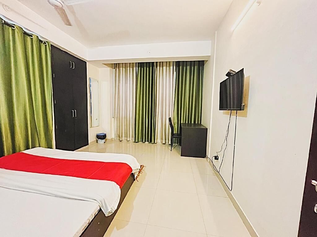 Une chambre d’hôtel avec un lit, une télévision, un bureau et une chaise.