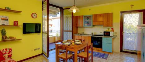 A compact living space with a dining area, kitchen, and a sofa.