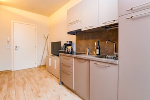 A modern kitchen with beige cabinets, a stainless steel sink, and a coffee maker. - Casa Vino in Sal With 1 Bedrooms and 1 Bathrooms (Salò)