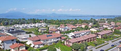 Un quartier résidentiel avec des maisons, une piscine et une vue sur la mer et les montagnes.