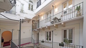 A multi-level interior with balconies, staircases, and potted plants. - Downtown Apartment in Sal (Salò)