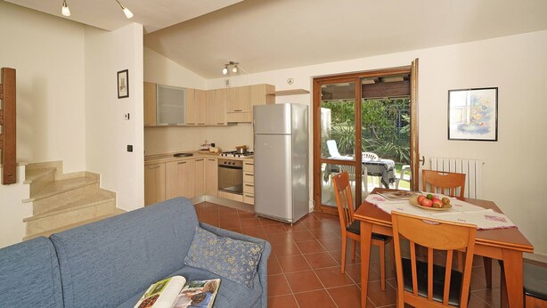 Un espacio habitable compacto con kitchenette, comedor y sofá.