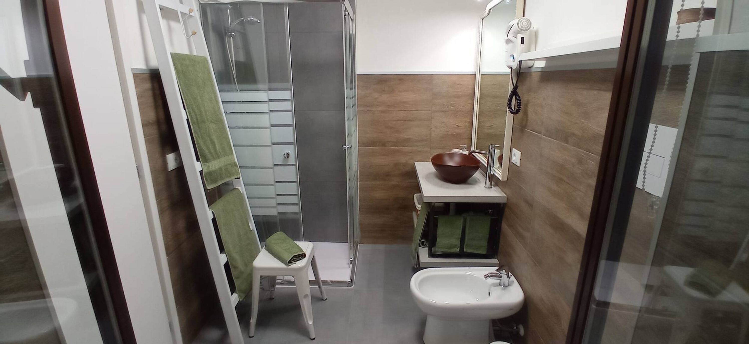 Ein modernes Badezimmer mit Duschkabine aus Glas, einem Waschbecken und einem Waschtisch mit integriertem Becken.
