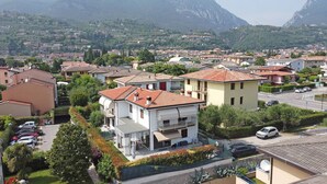 A residential area with houses, a street, and mountains in the background. - Casa Della Bougan-ville (Toscolano Maderno)