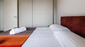 A hotel room with a bed, a wardrobe, and a red headboard. - Fasanella 50 in Toscolano-maderno (Toscolano Maderno)