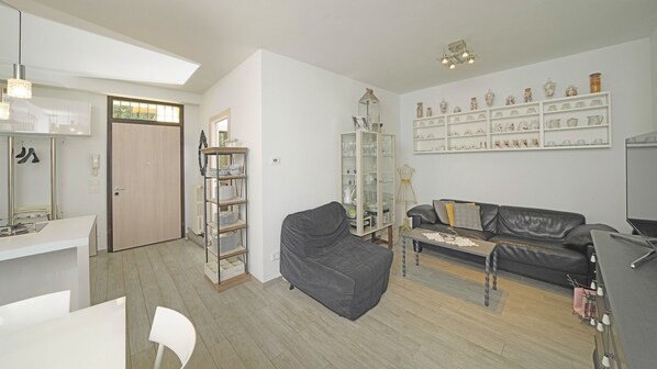 A modern living room with a sofa, a coffee table, and a bookshelf. - Garda Prestige Retreat (Moniga del Garda)