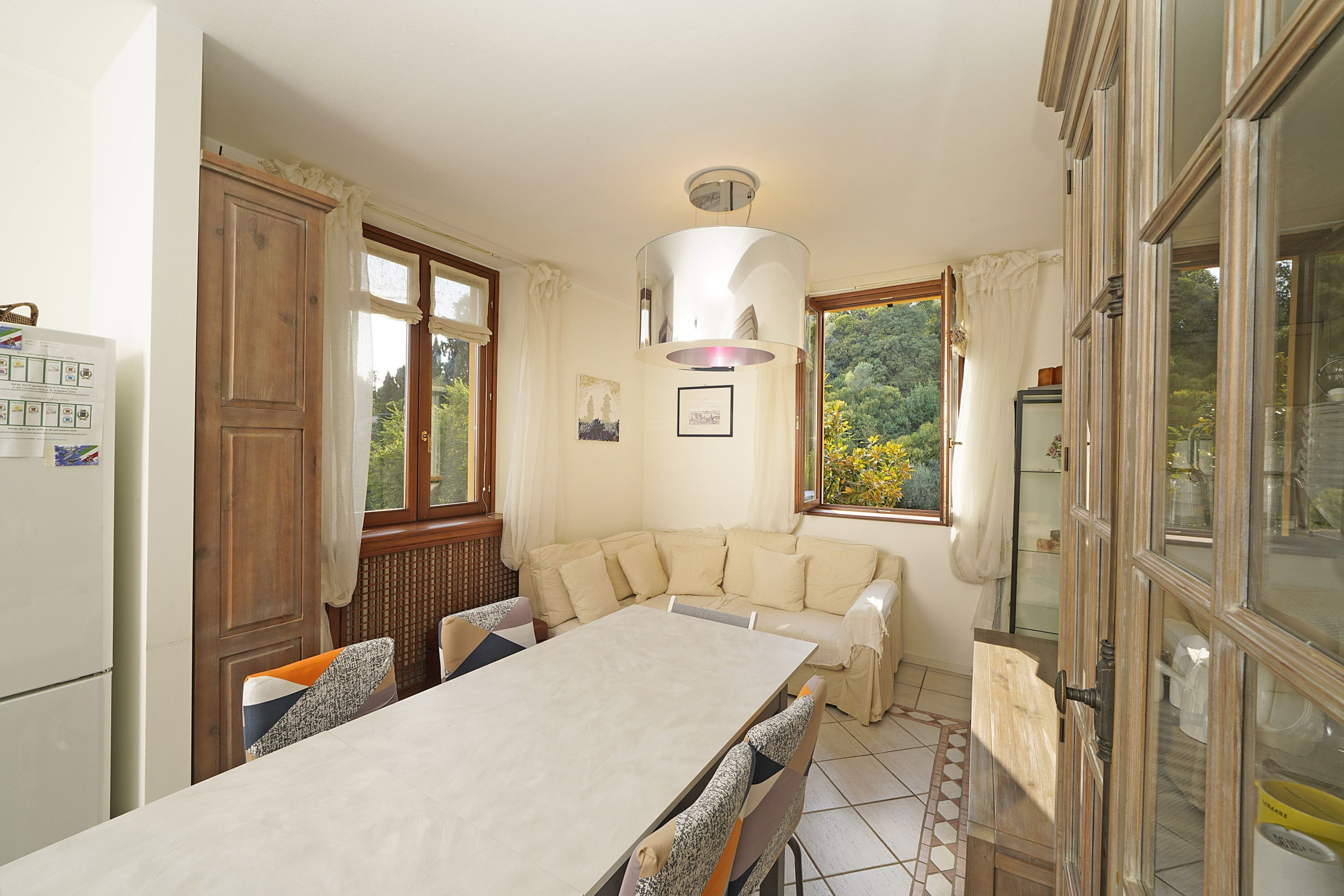 A kitchen with a dining table, wooden cabinets, and a built-in oven.
