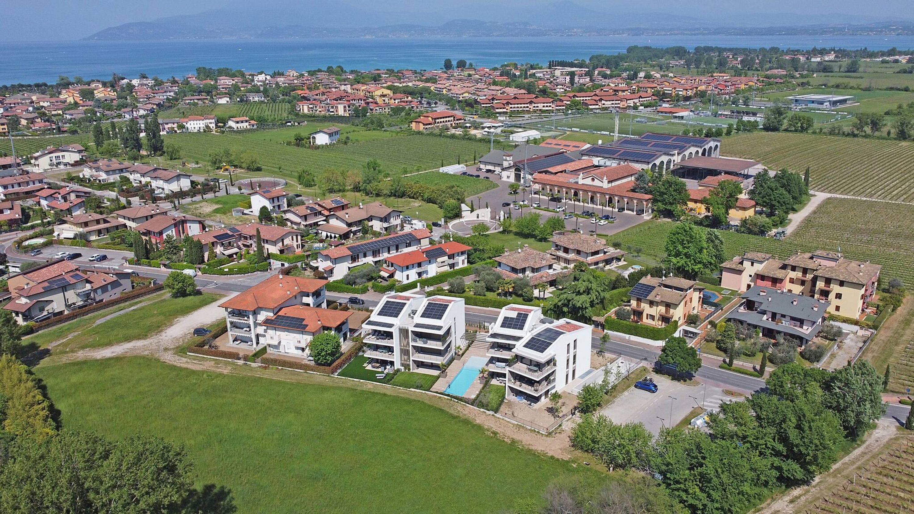 A residential area with houses, a swimming pool, and solar panels.