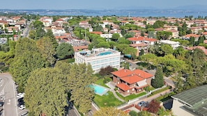 Un quartier résidentiel comprenant un immeuble moderne doté d’une piscine sur le toit et une maison traditionnelle avec un toit rouge.