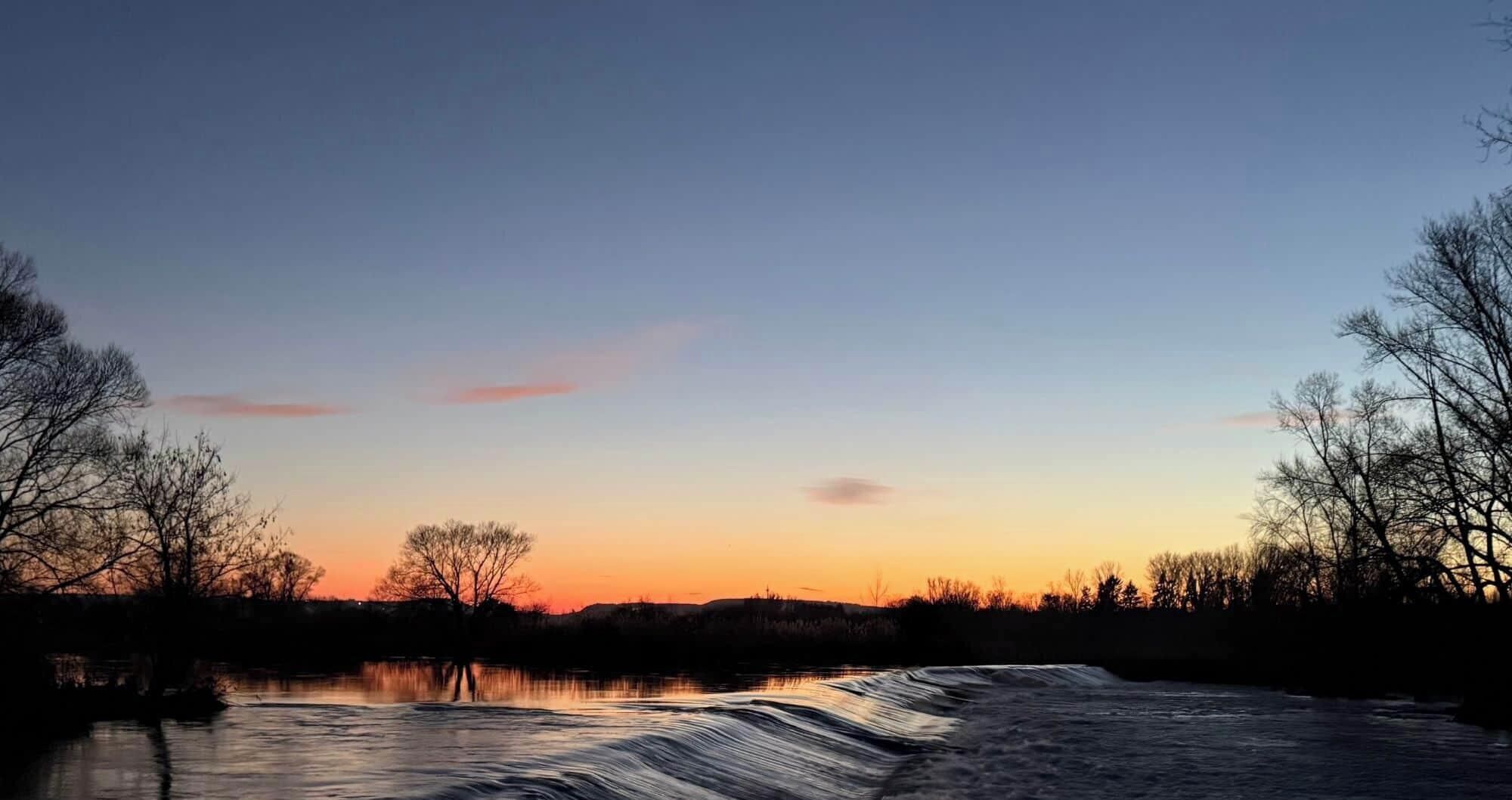 A river with a calm surface reflecting the sky.