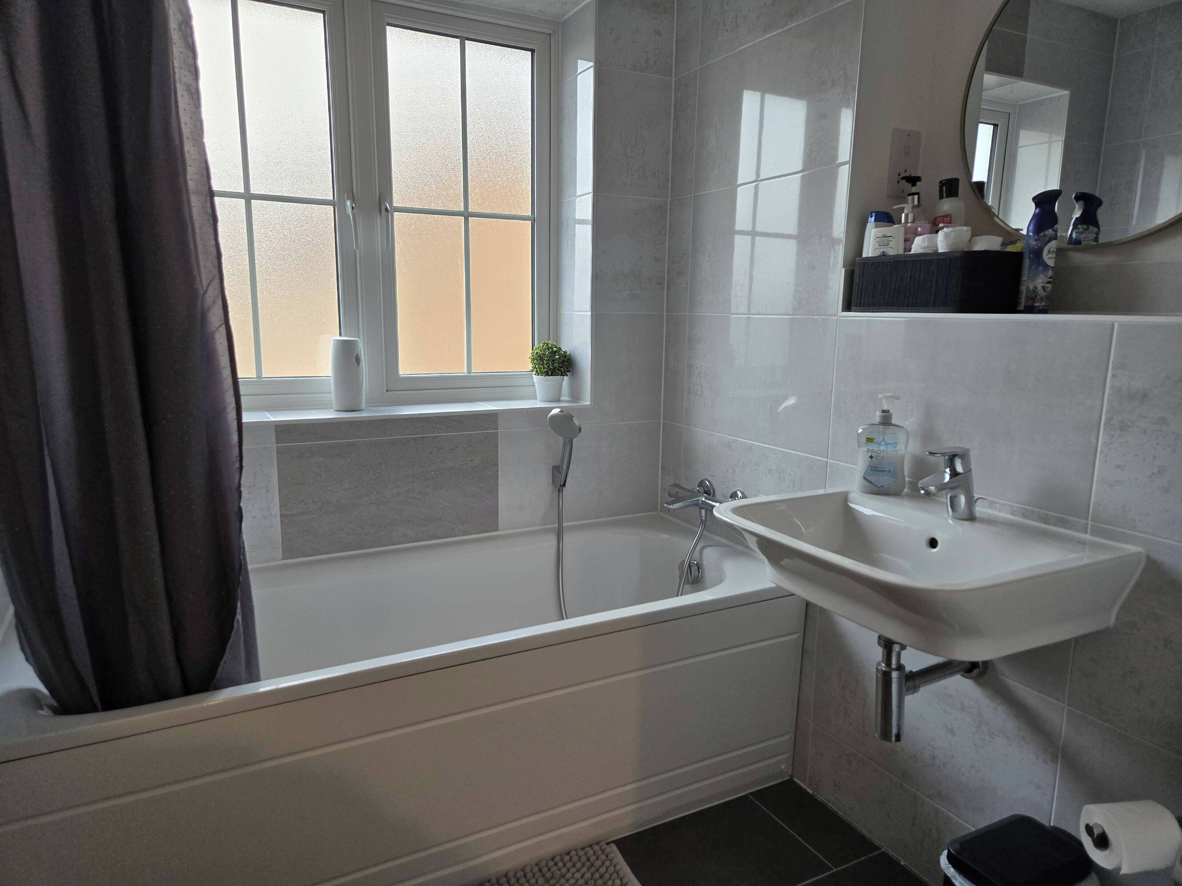 Un bagno moderno con vasca, lavandino e finestra.