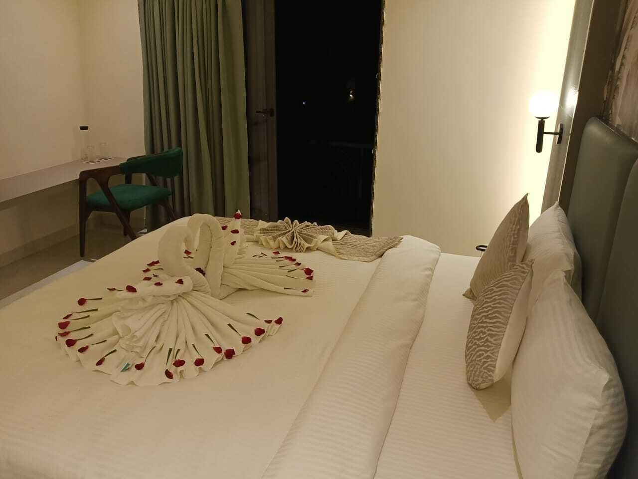 Una habitación de hotel con una cama bien hecha, una silla y un escritorio.