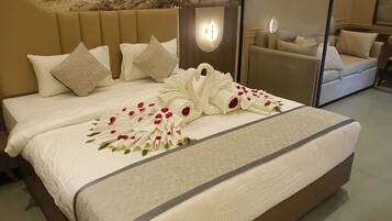 A neatly made bed with a decorative swan and rose arrangement, a headboard, and a wall-mounted light fixture.