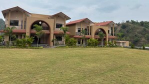 A two-story building with a flat roof and multiple balconies.