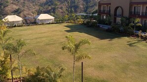 A grassy courtyard with tents and a building with balconies.