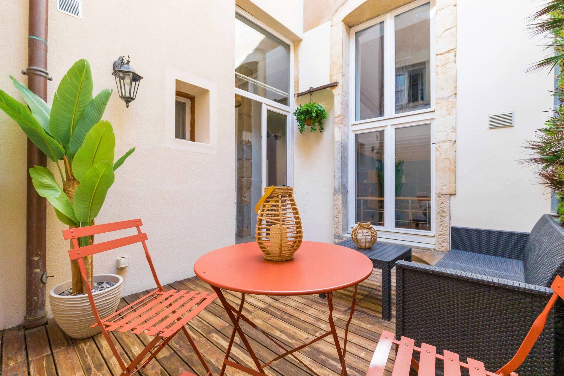 A patio with a round table, a wicker chair, and a wicker basket.