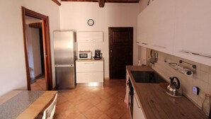 A compact kitchen with a refrigerator, microwave, and wooden countertop. - Casa Carlo - Isola d`Elba (Rio Marina)