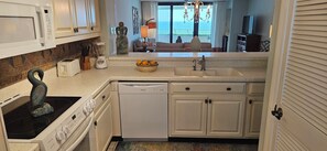 A kitchen with a microwave, toaster, blender, and a bowl of oranges on the counter. - Eden E 205 Gulf Front Condo with Stunning Views! (Pensacola)