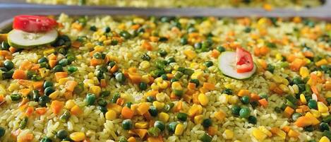 A tray of fried rice with various vegetables and garnishes.