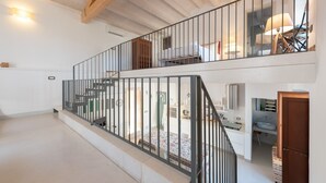 Ein geräumiger Innenraum mit einer Treppe zu einer zweiten Etage, einer Küchenzeile und einem Essbereich.