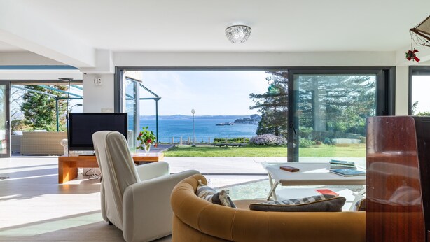 A modern living room with a large window, a flat-screen TV, a sofa, and a coffee table.