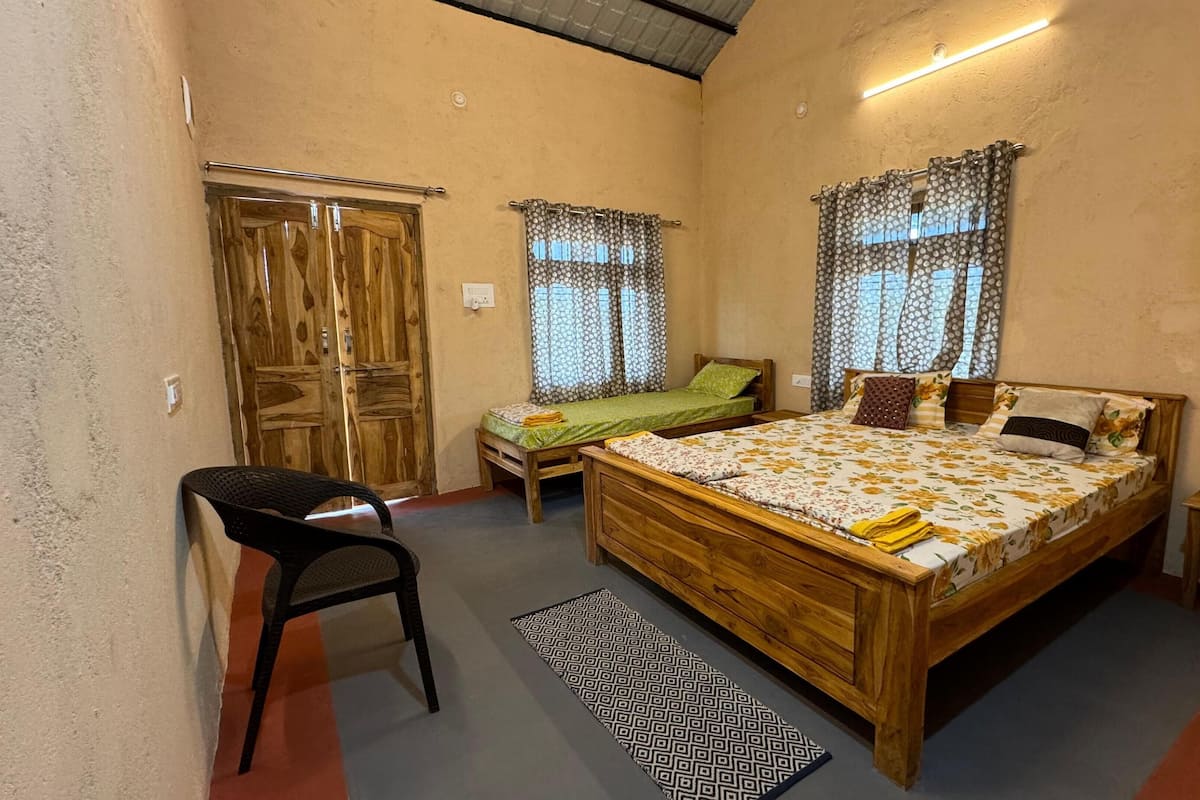 Une chambre à coucher avec un lit en bois, deux tables de chevet, une chaise et une petite table.