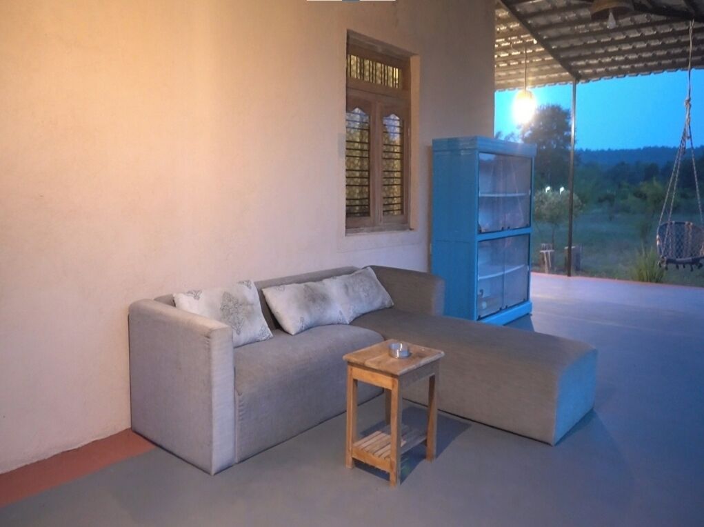 Et opholdsområde med sofa, et lille træbord og en blå reol.