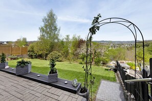 A rooftop garden with a view of the city, a wooden fence, and a metal archway. - Apartment No. 1 with Terrace (Attendorn)