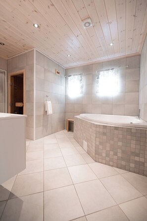 A modern bathroom with a wooden ceiling, a bathtub, and a shower area. - Skjolden Resort (Skjolden)