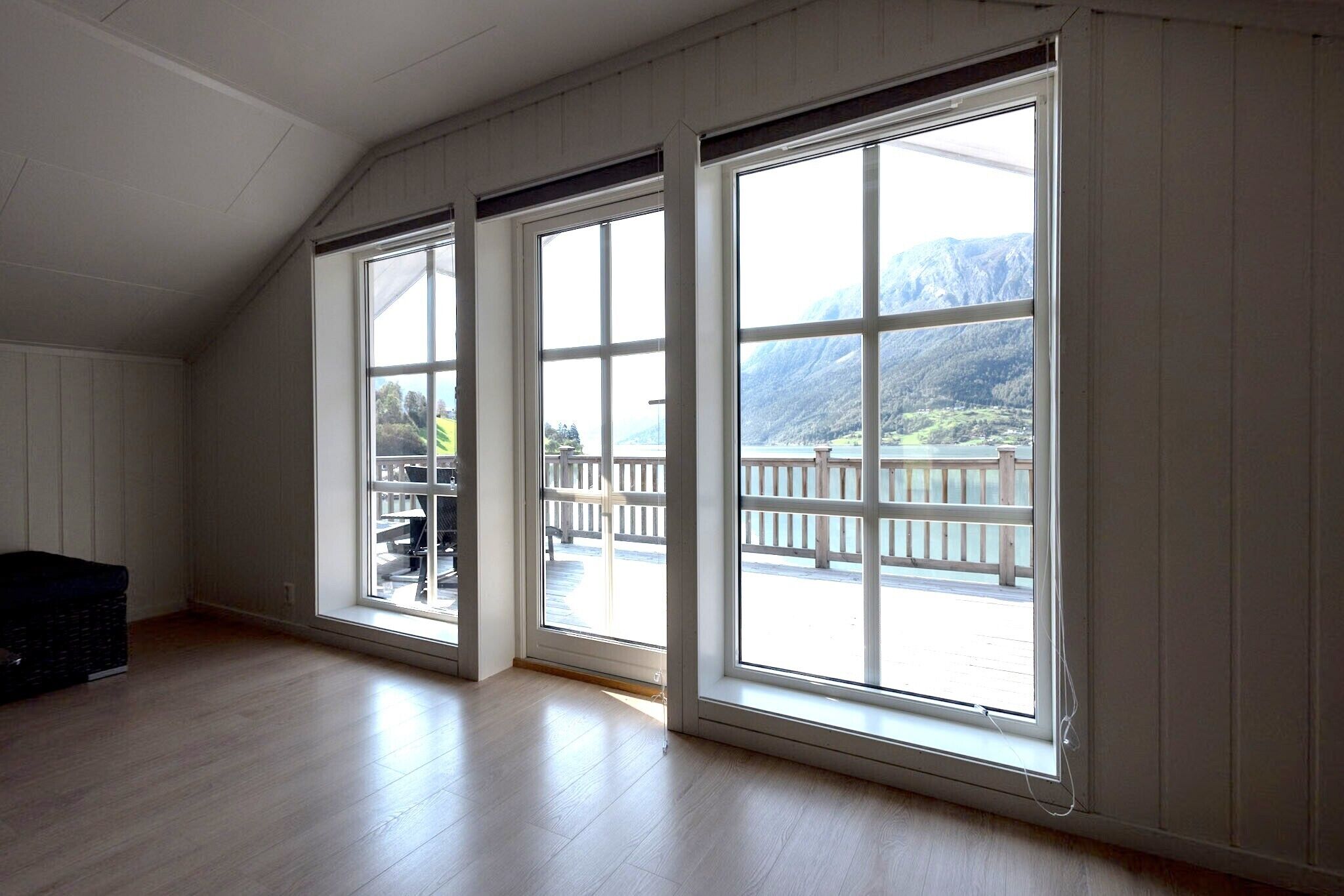 Ein Zimmer mit großen Fenstern, Holzböden und Bergblick.
