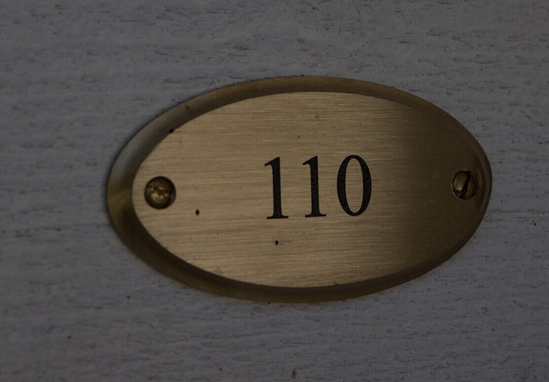 A brass plaque with the number 110.