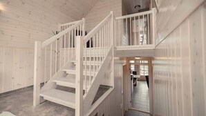 Interior de madera con una escalera que sube a un segundo piso.