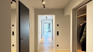 A hallway with a wooden floor leading to a bright room with a window. - Resort Schloss Reinharz (Bad Schmiedeberg)