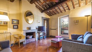 A living room with a fireplace, a television, and a sofa. - NAVONA PENTHOUSE APARTMENT WITH TERRACES (Roma)