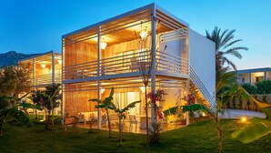 A modern multi-story building with large glass windows and a wooden interior. - Flamm Residences (Bodrum)