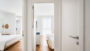 A hotel room with a wooden floor, a bed, a bedside table, and a mirror. - Flamm Residences (Bodrum)