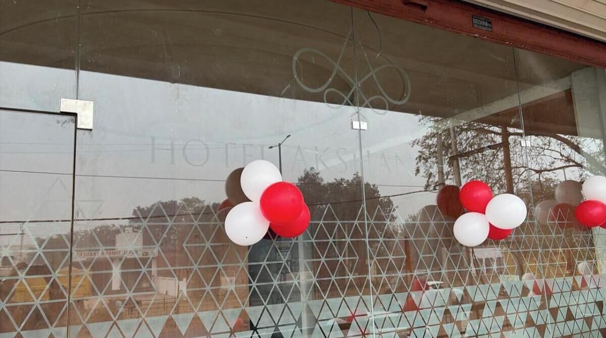 A window with a geometric pattern and a reflection of a building.