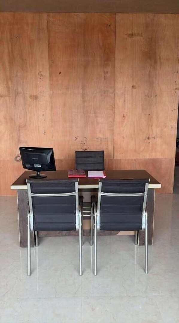 Ein moderner Arbeitsplatz mit dunklem Schreibtisch, zwei Stühlen und einem Computermonitor.